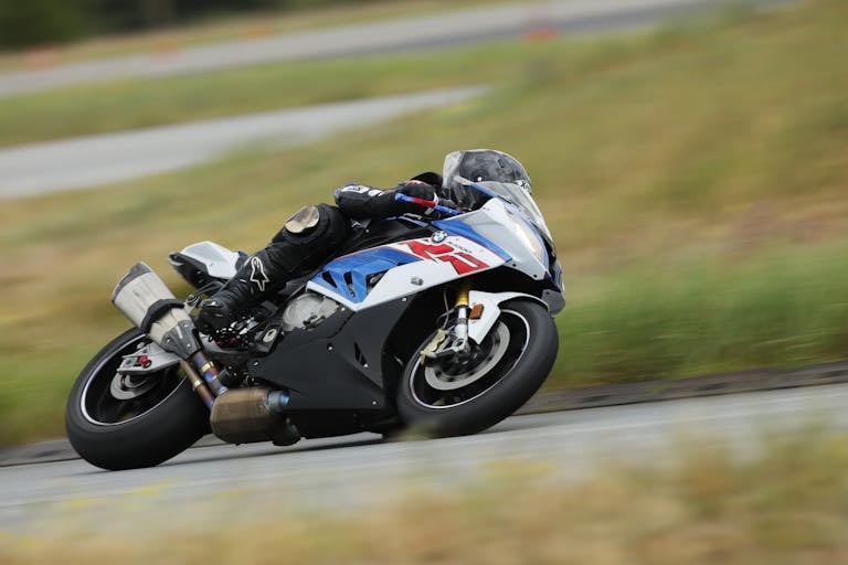 Racer leaning into a corner on a high-performance motorcycle during a race.