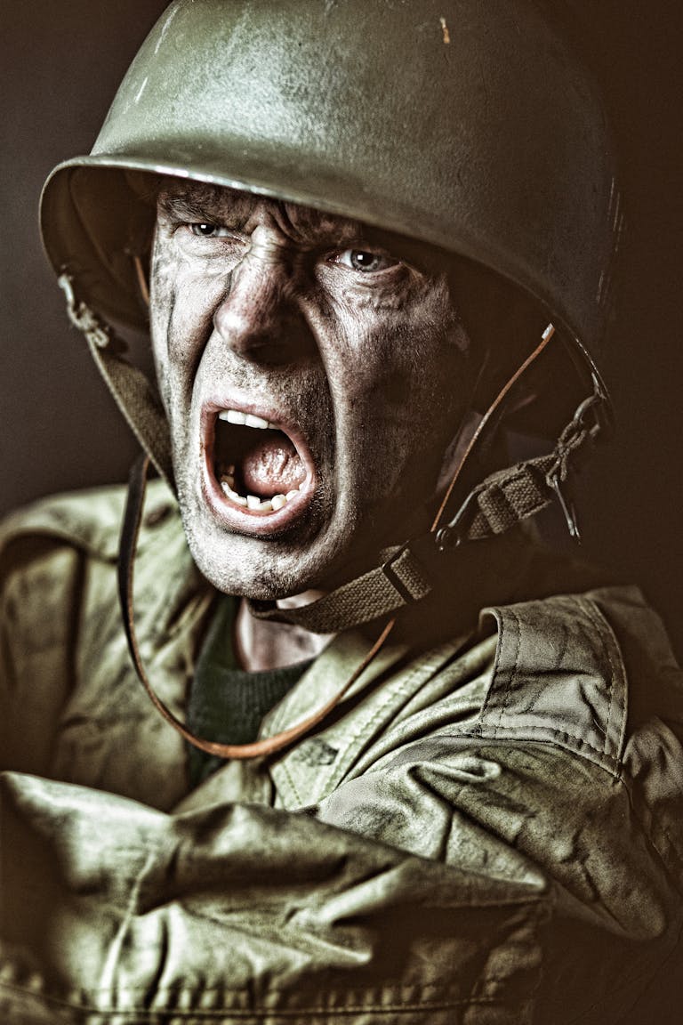 Close-up of a soldier in camouflage shouting during a military action scene.