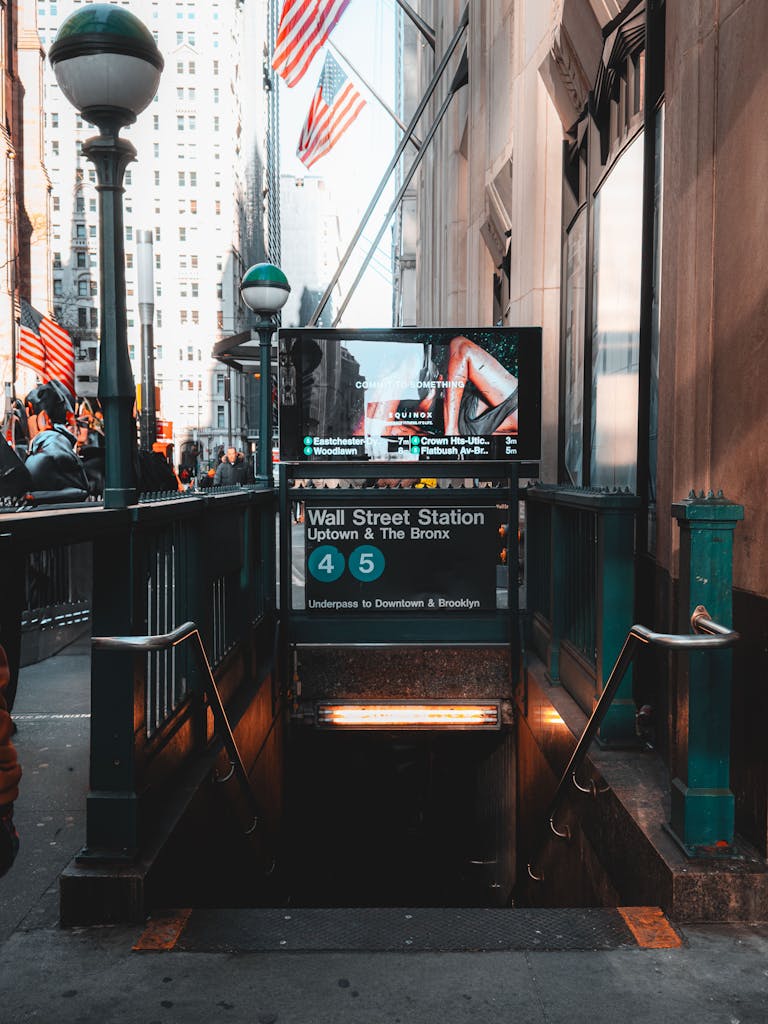 Iconic Wall Street subway entrance with American flags in NYC.