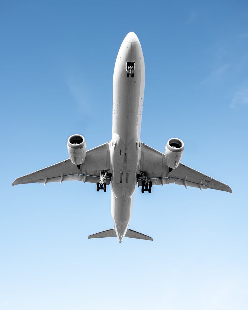 Low angle shot of an airplane flying against a clear blue sky in Morrisville, NC.