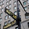 Street signs at the intersection of Wall Street and Broadway in New York City.